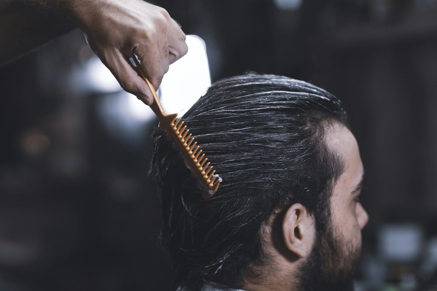 Illustrative close-up of a man's side-parted hair being combed, not an RS customer
